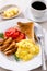 Scrambled egg breakfast with sausages, tomatoes and coffee