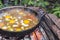 Scrambled eggs on a campfire camping in the nature Shakshouka national cuisine