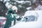 Scraping ice off the car after heavy snowfall covered it parked outdoors