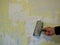 scraping off wallpaper residues from the wall with a spatula