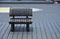 Scratched dark brown color wooden bench on the wood panel floor