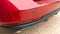 Scratched red car rear bumper in minor accident street vehicle damaged in collision