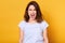 Screaming emotional angry woman isolated over yellow studio background. Half length portrait of young brunette female wearing