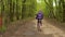 Screaming girl cool, in the spring forest. Riding a bike on the road