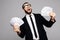 Screaming man in official suit holding money cash standing isolated over grey wall background.