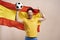 Screaming Spanish fan holding flag and soccer ball