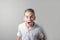 Screaming teenager boy in a white shirt on bright background