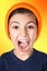 Screaming young boy with big head on orange background