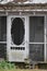 Screen Door with White rockers on the porch