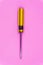 screw driver yellow and black plastic handle on pink pastel