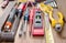 Screwdriver, hammer, tape measure placed on the wooden floor.