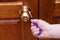 Screwdriver in hand. Screws a metal handle on wooden door
