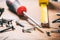 Screwdriver and nails on wooden background