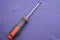 Screwdriver with rubberized red-black handle and black tip