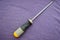 Screwdriver with a rubberized yellow-gray handle