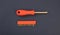 Screwdriver, socket wrench and set of replaceable bit, orange rubber handle on blue background