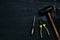 Screwdrivers, hammer, pliers and tools on a black wooden table. Top view