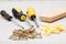 Screwdrivers, wooden block and screws on white wooden background