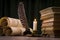 Scrolls of parchment, a stack of books, and a lit candle