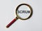 Scrum word through magnifying glass. Concept of methods in management