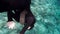 Scuba diver diving underwater in wetsuit. Pliant girl performing trick in scuba diving. Sea water and beauty of