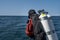 A scuba diver enters the water. Giant stride enter. Twin set tank. Ocean and blue sky in the background