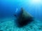 A Scuba diver explores a sunken shipwreck in the mediterranean sea