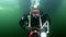 Scuba diver with flashlight and photo-video camera underwater.