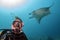 Scuba diver and Manta in the blue ocean background portrait