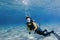 Scuba diver over white sand