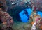 Scuba diver by sea cave.