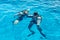 Scuba divers dive into the clear blue water in the sea