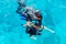 Scuba divers dive into the clear blue water in the sea