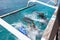 Scuba divers doing back flip into blue transparent sea from a boat`s board. There are several ways to get off the boat