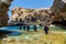 Scuba divers entering the water of a small canyon