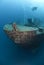 Scuba divers exploring the bow of a shipwreck. Re