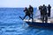 Scuba divers jump from boat in blue sea in Egypt