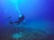 Scuba Divers swimming over the live coral reef full of fish