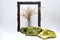 Sculpted wooden frame, with a smooth cloth, satin scarf, and a glass vase with dried flowers isolated on a white background.