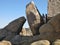 Sculptural granite boulders with visible molten rock intrusions and a triangular window to the desert landscape beyond