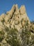 Sculptural granite rock formation with triangular peaks set against a blue Mojave Desert sky