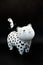 Sculpture of a cute white, black spotted cat made of porcelain