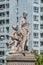 Sculpture of engineer and scholar on Zoll Bridge in Magdeburg and multistore building in background, Germany, contrast old and new