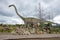 Sculpture herbivorous dinosaur Mamenchisaurus cloudy by day. Paleontological children`s Park
