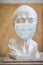 Sculpture of the male face of the elderly in a medical mask. Quarantine during coronavirus