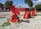 Sculpture of a red dragon snake undulating in and out of rocky ground in Dallas, Texas.