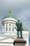 Sculpture of the Russian Emperor Alexander II (1894) on background of the dome of St. Nicholas Cathedral on a cloudy da