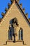 Sculpture of a saint in a robe, holding a cross