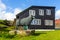 A sculpture of a sheep in front of a typical Faroe house. Faroe Islands