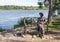 Sculpture of young woman sitting on the bench near riverbank